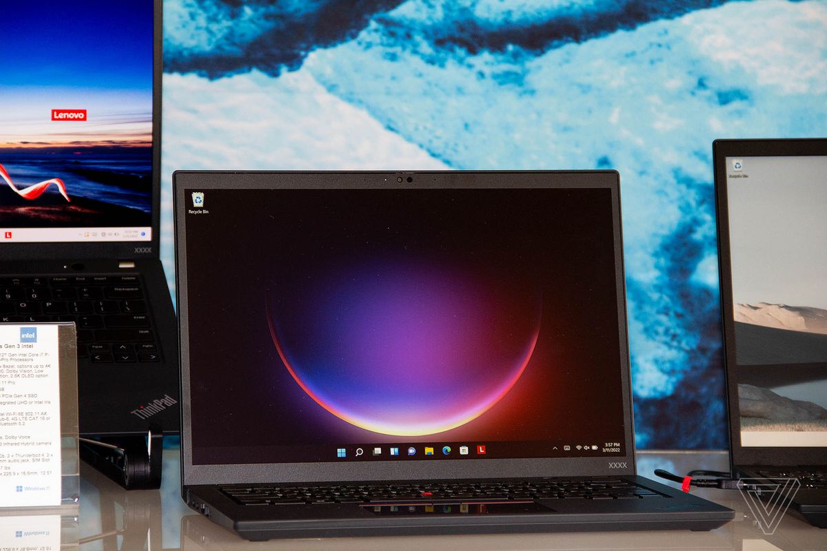 Lenovo ThinkPad T14s otwiera się na prostokątnym białym stole.  Na ekranie wyświetlany jest sierp księżyca.