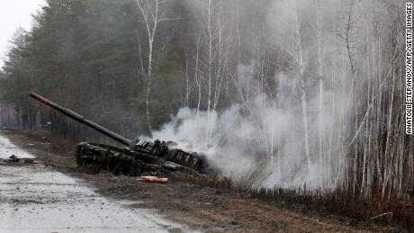 Dym unosi się z rosyjskiego czołgu zniszczonego przez siły ukraińskie na poboczu drogi w obwodzie ługańskim 26 lutego 2022 r.