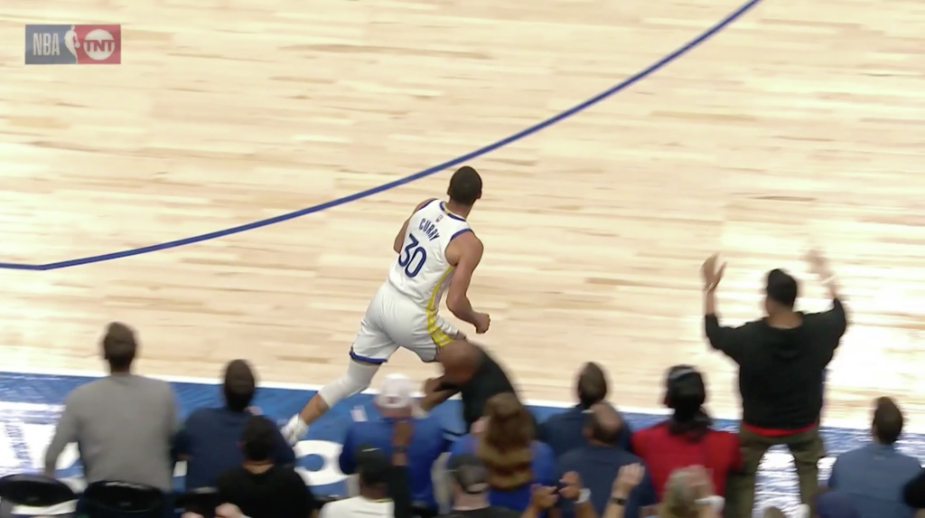 Steve Curry z Warriors leci nad tacą kelnera pod koniec pierwszej połowy przeciwko Mavericks