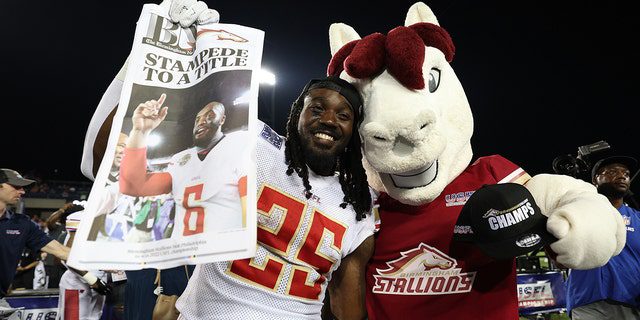 Bo Scarbrough nr 25 z Birmingham Stallions pozuje z maskotką Birmingham Stallion po pokonaniu Philadelphia Stars 33-30 i wygraniu meczu o mistrzostwo USFL w Tom Benson Hall of Fame 3 lipca 2022 w Canton w stanie Ohio.