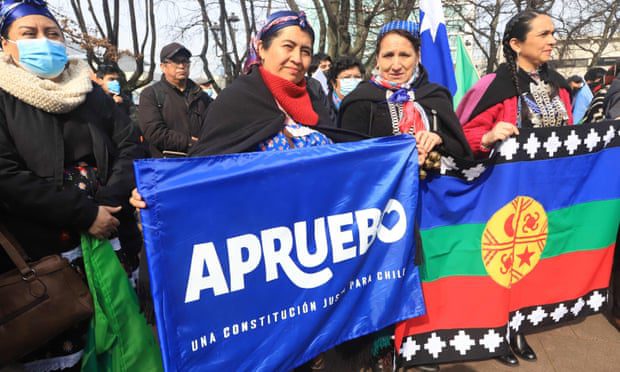 Rdzenni mieszkańcy Mapuche noszą flagi zatwierdzenia nowej konstytucji w Temuco w Chile w tym miesiącu.