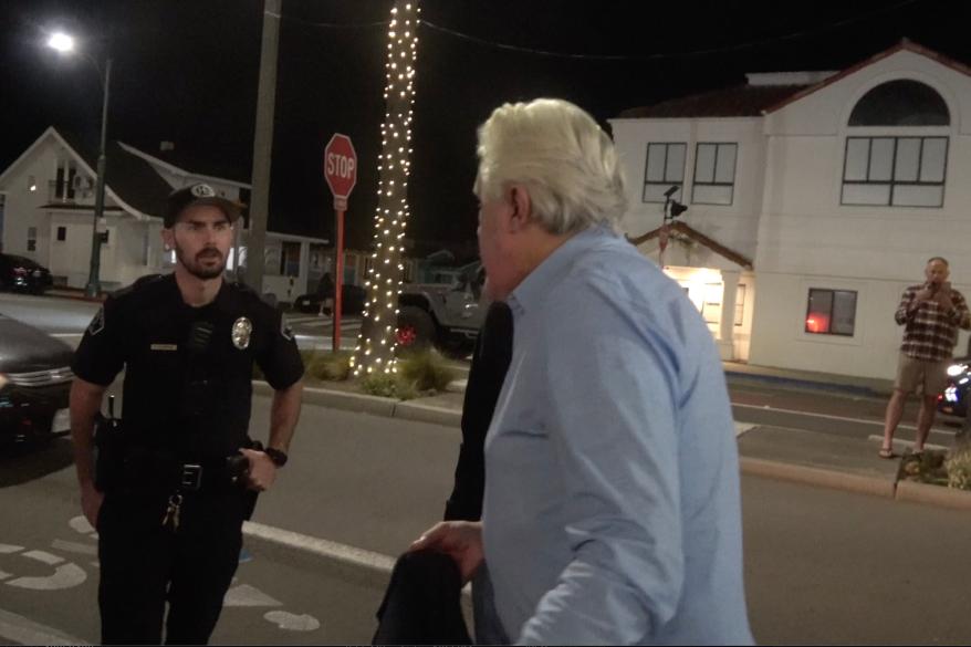 Zdjęcie Jaya Leno rozmawiającego z policjantami z Kalifornii.