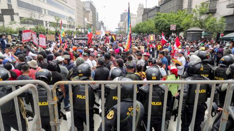 Funkcjonariusze policji stoją na straży, gdy ludzie gromadzą się przed Kongresem Peru po tym, jak prezydent Pedro Castillo powiedział, że rozwiąże zgromadzenie 7 grudnia.